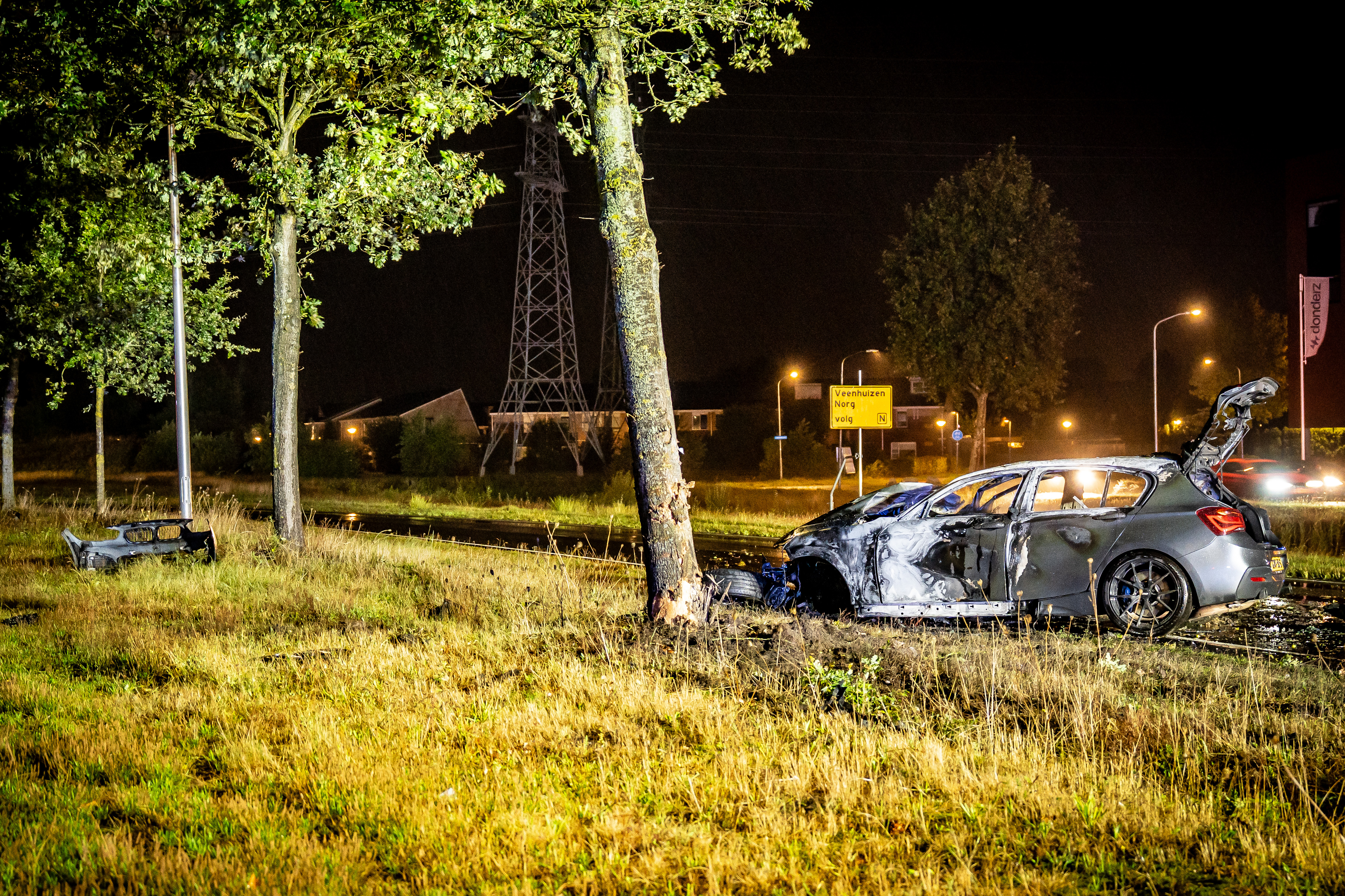 Auto vliegt in brand na forse botsing op boom in Assen