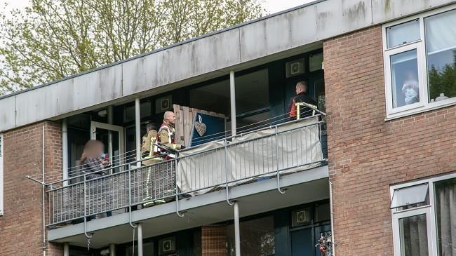 Kindje sluit vrouw buiten op het balkon