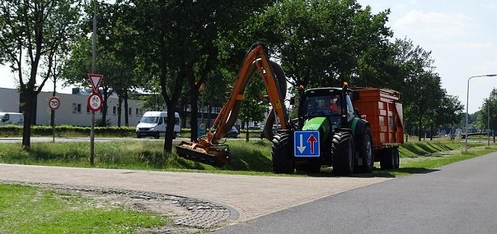 Grasmaaiers maaien bermen in Assen