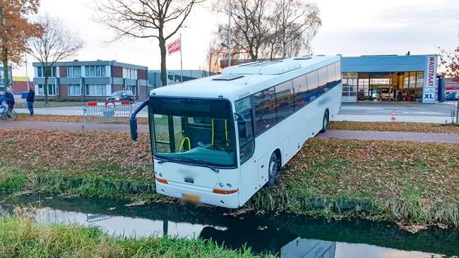 Bus rijdt in Assen de sloot in