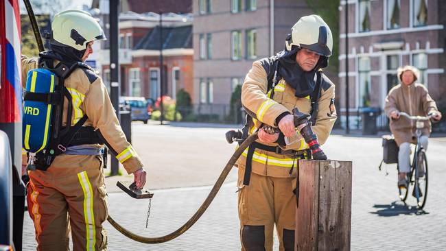 Brandweer blust smeulend hout 