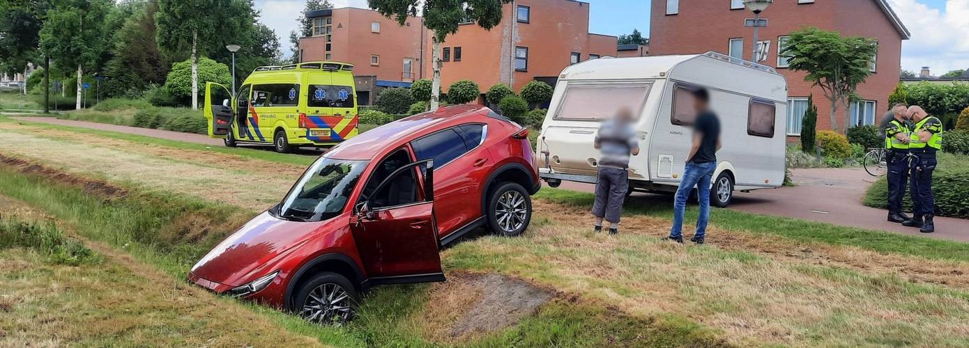 Automobilist schiet met auto en caravan de sloot in