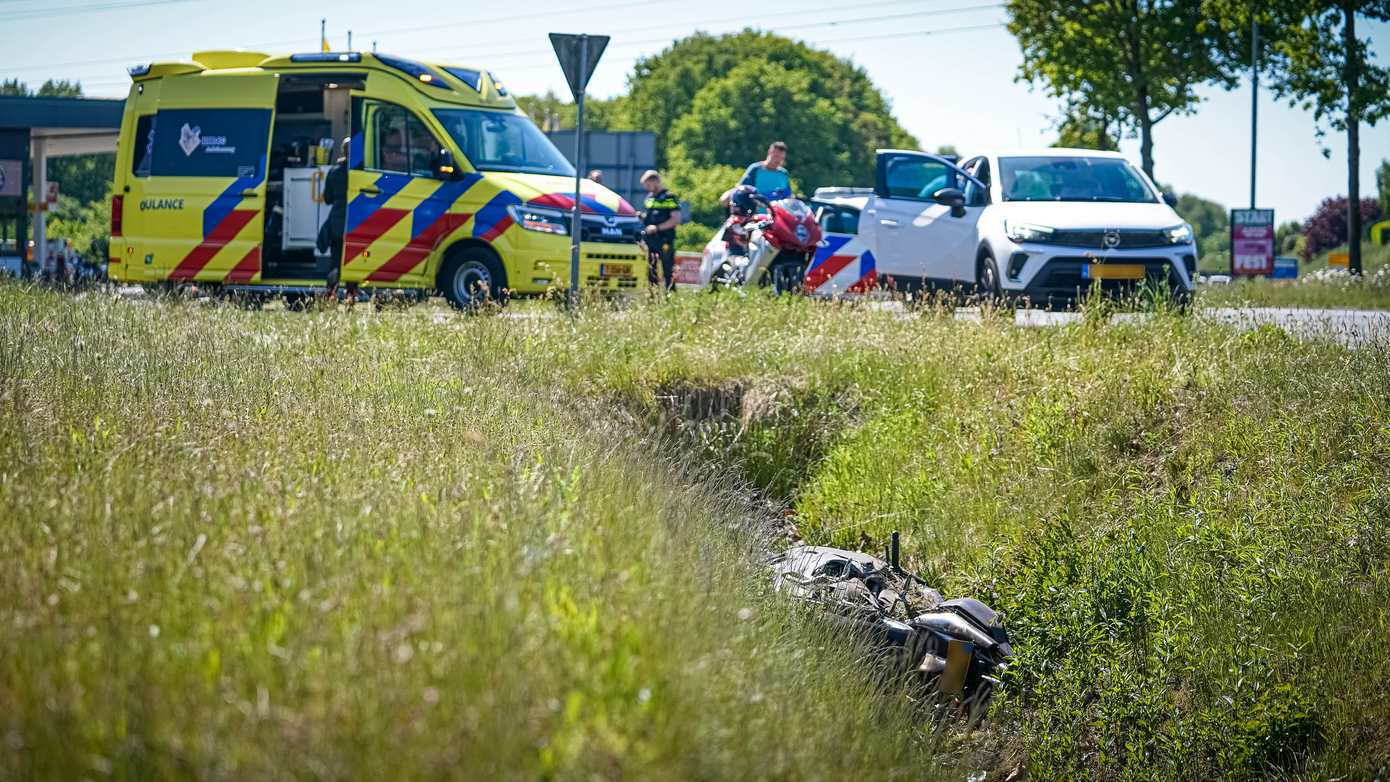 Motorrijder wordt afgesneden door auto en belandt in sloot